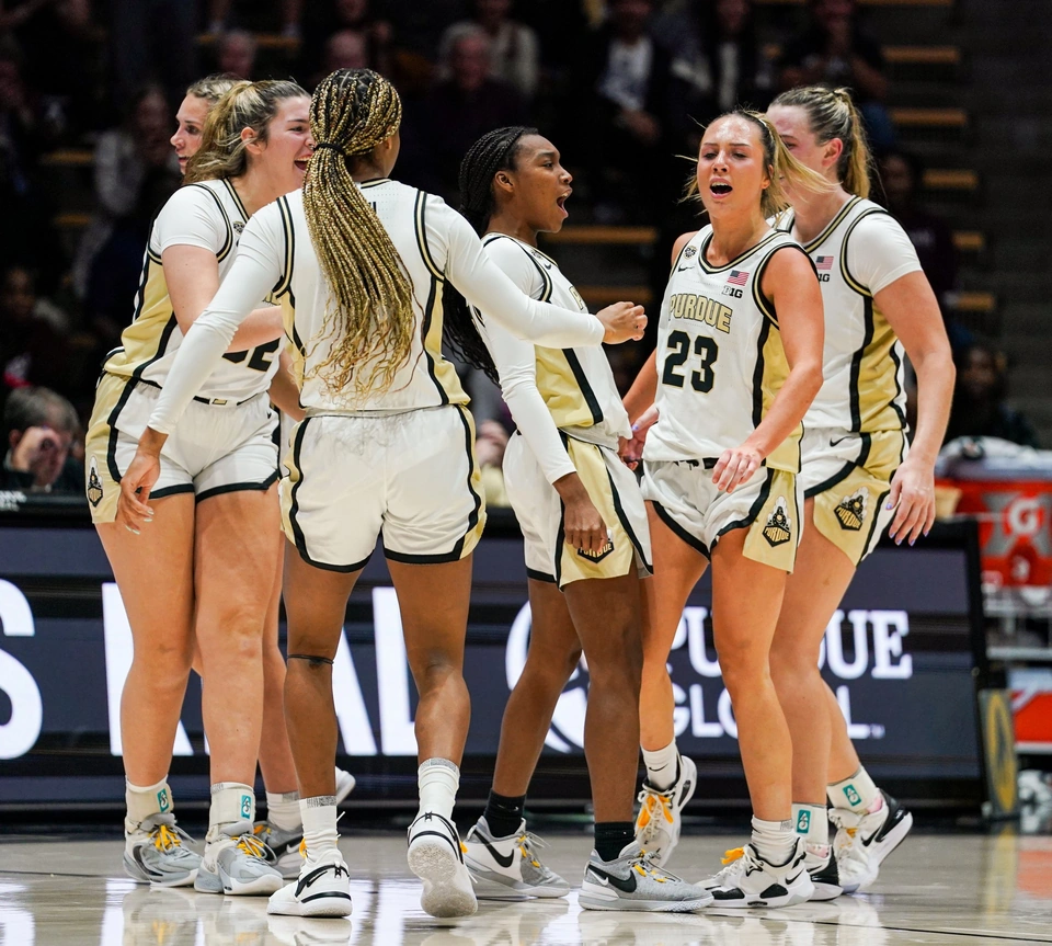 Purdue women's basketball players celebrating in a huddle