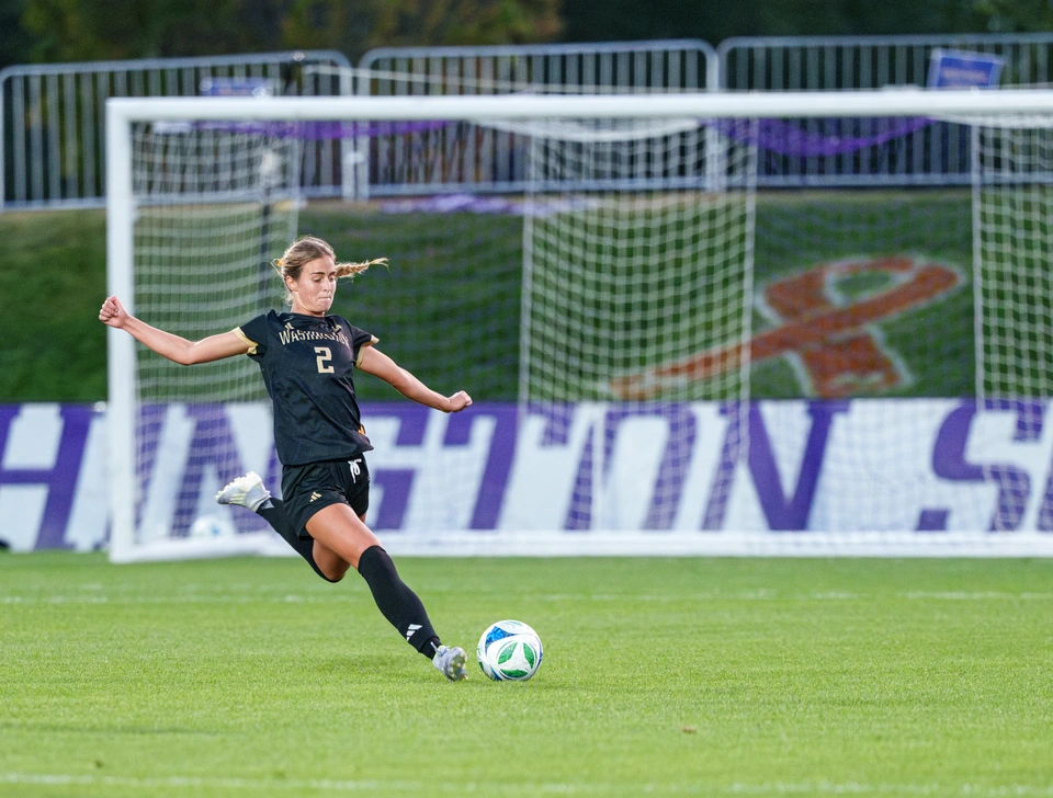 Washington player striking the ball in front of goal